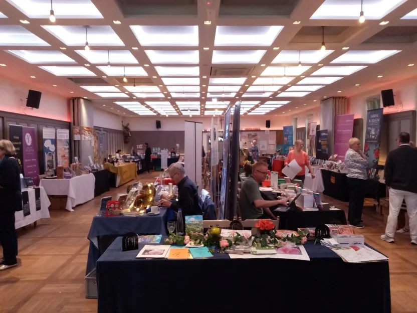 Blick in den Hauptsaal. An beiden Wänden sind Tische aufgebaut, und in der Mitte steht nochmals eine doppelte Reihe.